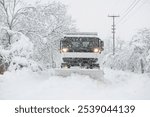 Snow plow removing snow from street.