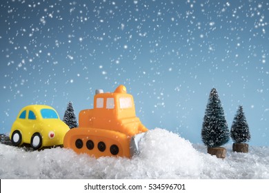 Snow Plow. Toy Car In A Little Winter Landscape. Concept Of Road Cleaning And Road Safety.