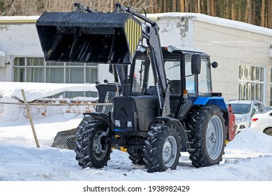 A Snow Plow Tractor Is Parked On The Side Of The Road