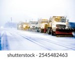 Snow plows in severe blizzard preparing for storm clearing street driving