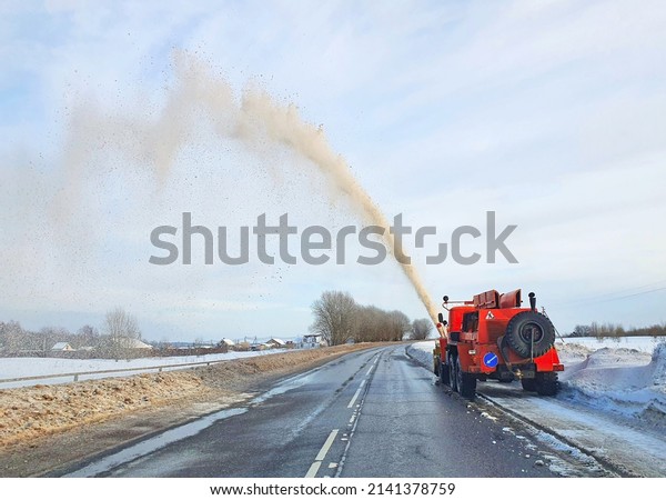 Snow\
removal equipment at work. A huge snowplow, sprays a snow avalanche\
with a long jet. Unusual cleaning of\
snowdrifts