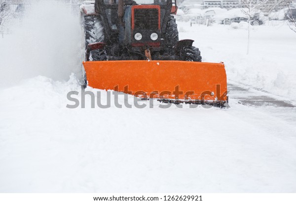 Snow  removal machine cleans the street\
of snow. Cleaning road from snow storm at\
winter