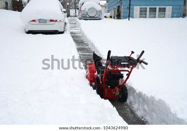snow removal on driveway after blizzard in\
residential district