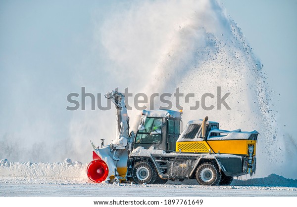 Snow removal vehicle in\
the airport. Snow blower. Cleaning airport from snow. Cleaning\
runway from snow