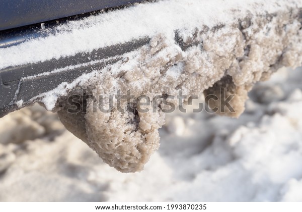 Snow with salt on the car\
chassis.