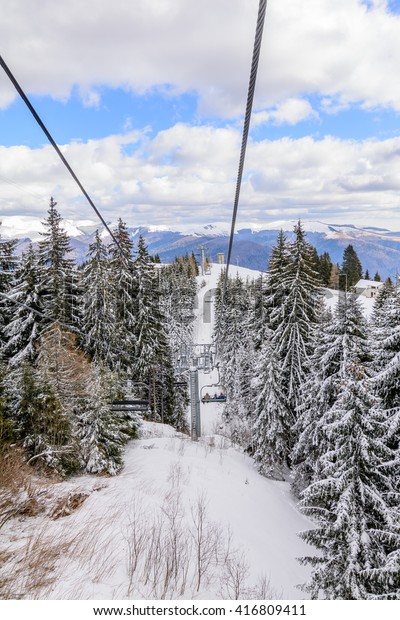 Snow scene  from Carpathian Mountains,\
Romania. Panoramic vertical view from cable car over mountains\
covered with snow in\
wintertime.