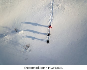 Snow showeing, hiking, cross country skiing on a sunny day leaving tracks in snow and ice in Swiss Alps in Winter Scenery Graubünden Pontresina. Concept: Winter tourism, sport, outdoor, winter sports