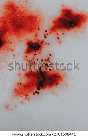 snow splattered blood. forensic blood patterns. blood droplets on icy surface. Bloody trace on snow texture.Close-Up of Red-Stained Snow Surface 