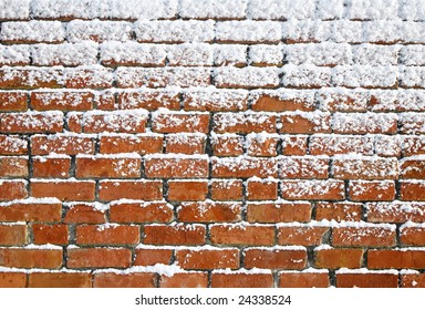 Snow sticking to an old brick wall.