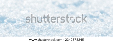 Snow surface close-up. Winter background with snow texture and beautiful bokeh. Shallow depth of field and blur. Perfect for Christmas and New Year design. View with copy space.