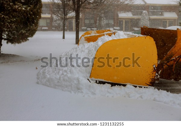 snow sweeper works on the snowy street with backhoe\
removes snow from