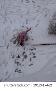 Snow Sweeps, Covers The Whole Earth. A Girl In A Pink Jacket Rides In The Snow, Plays And Enjoys The Bliss. Place To Place Text