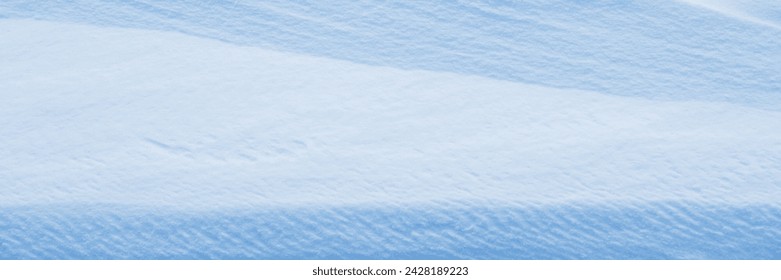 Snow texture. Wind sculpted patterns on snow surface. Wind in the tundra and in the mountains on the surface of the snow sculpts patterns and ridges. Arctic, Polar region. Winter panoramic background.