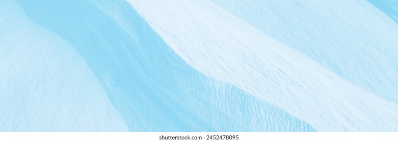 Snow texture. Wind sculpted patterns on snow surface. Wind in the tundra and in the mountains on the surface of the snow sculpts patterns and ridges (sastrugi). Arctic, Polar region. Winter background