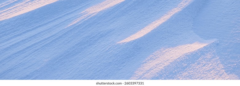 Snow texture. Wind sculpted patterns on snow surface. Wind in the tundra and in the mountains on the surface of the snow sculpts patterns and ridges. Arctic, Polar region. Winter panoramic background.