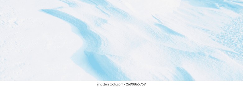 Snow texture. Wind sculpted patterns on snow surface. Wind in the tundra and in the mountains on the surface of the snow sculpts patterns and ridges (sastrugi). Arctic, Polar region. Winter background