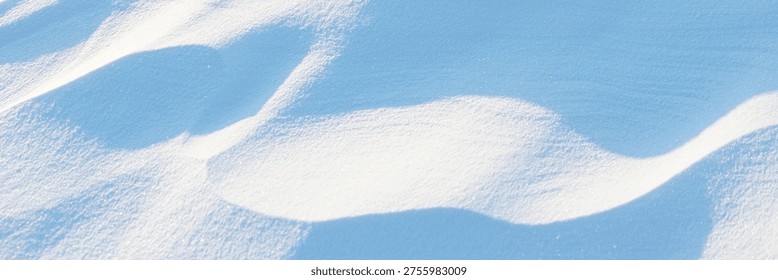 Snow texture. Wind sculpted patterns on snow surface. Wind in the tundra and in the mountains on the surface of the snow sculpts patterns and ridges. Arctic, Polar region. Winter panoramic background.