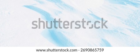 Snow texture. Wind sculpted patterns on snow surface. Wind in the tundra and in the mountains on the surface of the snow sculpts patterns and ridges (sastrugi). Arctic, Polar region. Winter background