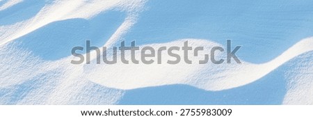 Snow texture. Wind sculpted patterns on snow surface. Wind in the tundra and in the mountains on the surface of the snow sculpts patterns and ridges. Arctic, Polar region. Winter panoramic background.