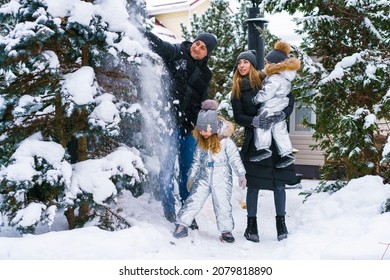 Snow Time, Snow Games. Winter Vacation. Cute Caucasian Kids Brother And Sister And Mom With Dad Are Playing In The Yard Of Their House. Snow Throwing Fun During Winter Break