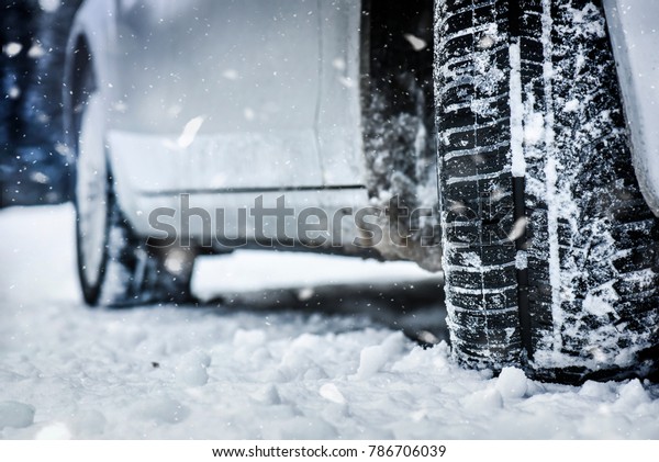 Snow tire in winter road. Winter tire on snow\
road. Car tire on winter