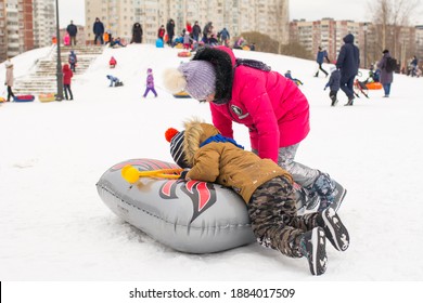 Snow Tube In Winter. Children On The Street In Winter, In The Park By The Snow Slide. Winter Fun, Walk. Russia, Saint Petersburg, December 27, 2020,