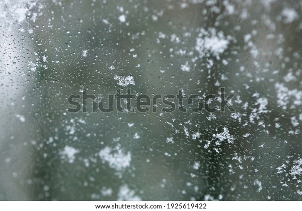 snow and water drops on the windshield of the car
                             
