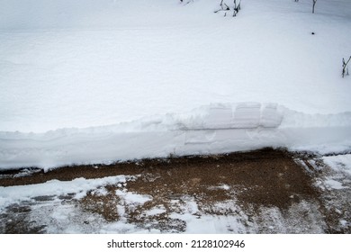 Snow Where A Gate Has Cut It To Show Its Depth And Scraped The Driveway In Front Of To Cut