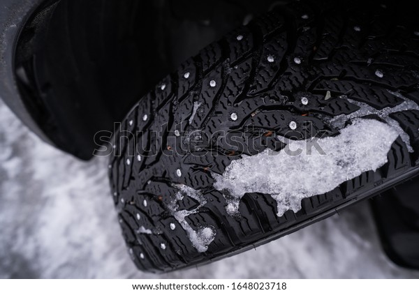 Snow or winter tires. Close up of car tires\
in winter on the snow covered\
road