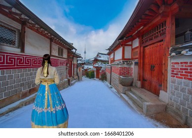 Snow In Winter With Womankorean National Dress. At  Bukchon Hanok Village.  In Seoul, South Korea