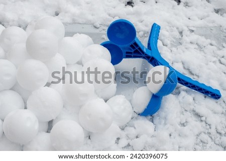 Snowballs formed with manual ball bead machine. Winter fun. Snow fight tool