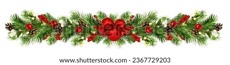 Snowberries with green twigs of Christmas tree, red decorations and cones in a festive garland isolated on white