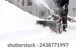 snowblower removes snow, a man cleans the yard outside