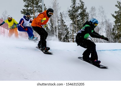 snowboard cross competition group of athletes downhill on snowy track