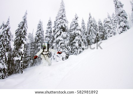Snowboarder doing jump on hill - winter forest