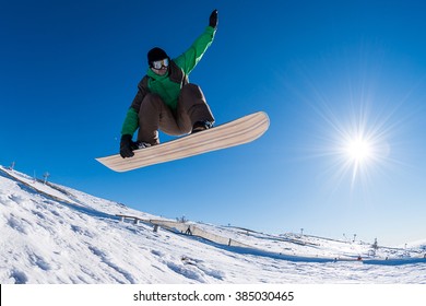 Snowboarder Executing A Radical Jump Against Blue Sky.