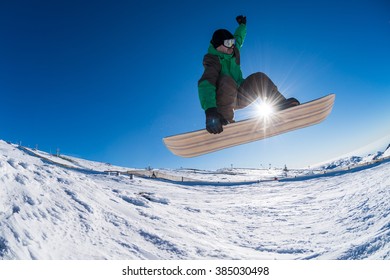 Snowboarder Executing A Radical Jump Against Blue Sky.