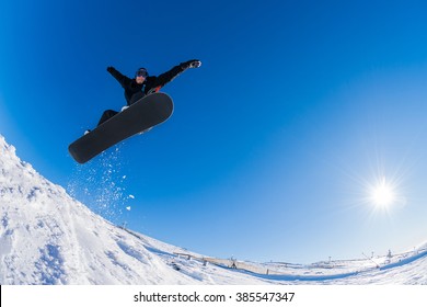 Snowboarder Executing A Radical Jump Against Blue Sky.