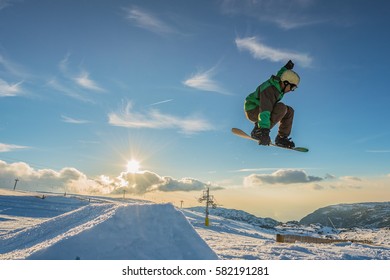 Snowboarder Executing A Radical Jump Against Sunset Sky.