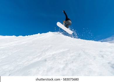 Snowboarder Executing A Radical Jump Against Blue Sky.