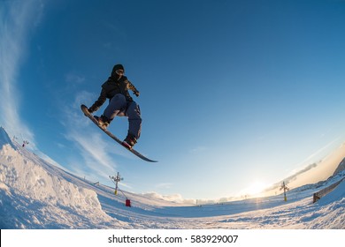 Snowboarder Executing A Radical Jump Against Blue Sky.