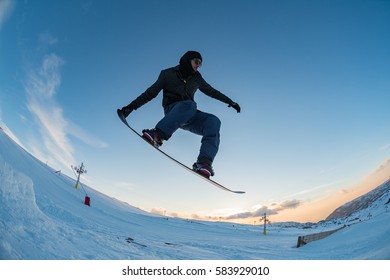 Snowboarder Executing A Radical Jump Against Blue Sky.