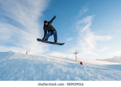 Snowboarder Executing A Radical Jump Against Blue Sky.