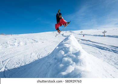 Snowboarder Executing A Radical Jump Against Blue Sky.