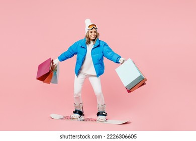 Snowboarder fun woman wear blue suit goggles mask hat ski jacket hold shopping package bags isolated on plain pink background Winter extreme sport hobby trip relax, Black Friday sale buy day concept