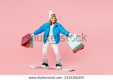 Snowboarder fun woman wear blue suit goggles mask hat ski jacket hold shopping package bags isolated on plain pink background Winter extreme sport hobby trip relax, Black Friday sale buy day concept