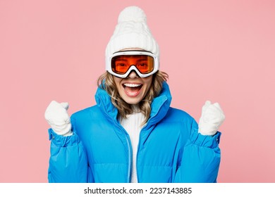 Snowboarder feliz mujer divertida usar traje azul gafas máscara sombrero chaleco acolchado de esquí sí gesto del ganador celebrar aislado en fondo rosa pastel negro claro Invernal deporte extremo hobby viaje de fin de semana relajación