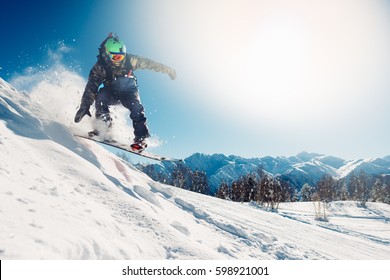 snowboarder is jumping with snowboard from snowhill