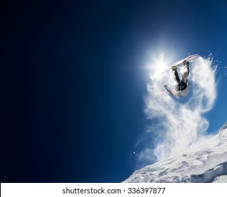 Snowboarder Making High Jump In Clear Blue Sky