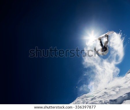 Snowboarder making high jump in clear blue sky
